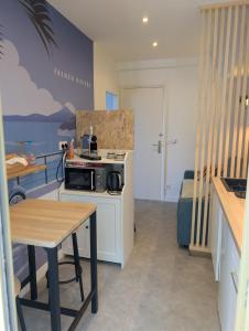 a small kitchen with a microwave and a table at Studio in a luxury community in Nice +23 photos