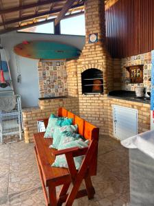 a room with a wooden bench with a brick oven at Casa Nova Praia Vivamar in Cabo Frio