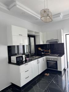 a kitchen with white cabinets and a microwave at Villa Mazzyd in Temlale