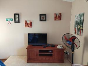 a living room with a television and a fan at Lacaz Vacances in Tamarin