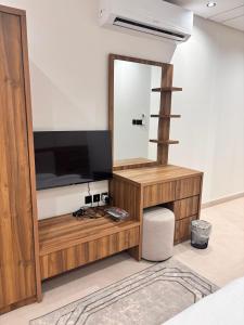 a living room with a television and a mirror at ايراد للشقق المفروشه in Dammam
