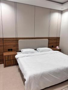 a bedroom with a large bed with white sheets at ايراد للشقق المفروشه in Dammam +10 photos