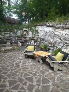 two chairs and a table on a stone patio at Cabin 4 Hill Station in Sarajevo