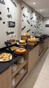 a buffet line with pies and cakes on plates at Hotel 15 de Julho in Foz do Iguaçu