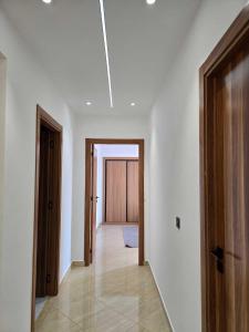 a hallway with white walls and wooden doors at panoramic sky 17 in Tangier +59 photos
