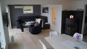 a living room with a black couch and a fireplace at Kvalheim Nordfjord in Myre
