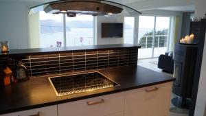 a kitchen with a counter top and a stove top oven at Kvalheim Nordfjord in Myre
