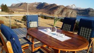 a wooden table on a deck with a view of the mountains at Kvalheim Nordfjord in Myre
