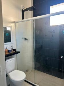 a bathroom with a toilet and a glass shower at Casa Nova Praia Vivamar in Cabo Frio +43 photos