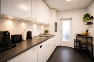 eine Küche mit weißen Schränken und einer Spüle in der Unterkunft Schängel Chic 21 in Koblenz