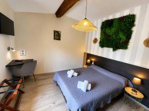 a bedroom with a bed and a table and a lamp at Hotel Saint Germain in Pézenas +50 photos