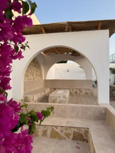 a patio with purple flowers in the foreground at Villa Mazzyd in Temlale