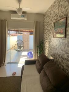 a living room with a couch and a stone wall at Casa Nova Praia Vivamar in Cabo Frio