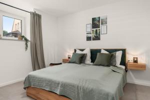 a white bedroom with a large bed and a window at Livesto Apartments im Zentrum Bad Driburgs - Modern, Parkplatz, Terrasse, Switch, SmartTV für Familien und B2B in Bad Driburg