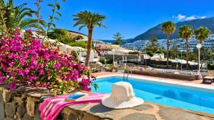 a hat sitting on a table next to a swimming pool at Apartamentos Panamá in Puerto Rico de Gran Canaria
