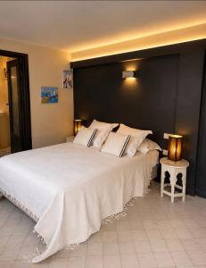 a bedroom with a large white bed with a black headboard at Studio Appartement Perdicaris en rez de jardin - maison dhotes Dar Tanja in Tangier