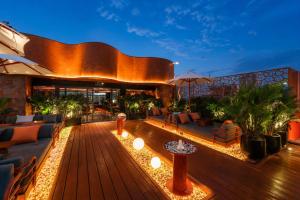 a building with a deck with couches and tables at KiN Hotel Ly Tu Trong Edition in Ho Chi Minh City