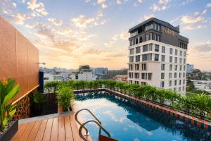 a balcony with a swimming pool on top of a building at KiN Hotel Ly Tu Trong Edition in Ho Chi Minh City