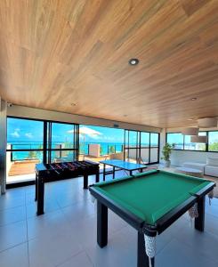 a pool table in a room with a view of the ocean at Maré alta flat 213 in Tamandaré