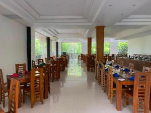 a dining room with wooden tables and chairs at Nice Place Resort in Dambulla