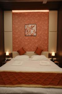 a bedroom with a large white bed with two pillows at Gamagashree Hotel and Fine Dine in Sāgar +3 photos