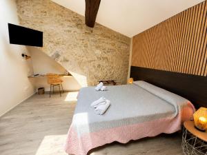 a bedroom with a bed with two towels on it at Hotel Saint Germain in Pézenas