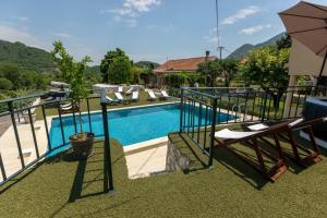 a swimming pool with two chairs and an umbrella at Aria in Cetinje