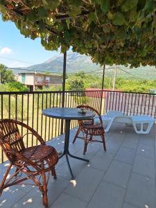 a table and chairs on a patio with a table at Apartmani Medojević in Radanovići