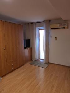 an empty living room with a television and a sliding door at Apartmani Medojević in Radanovići