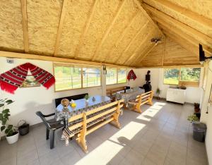a dining room with a table and benches at Cabana de Sub Deal Arieșeni in Arieşeni