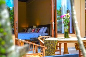 - un salon avec un lit, une table et des chaises dans l'établissement Griya Sriwedari, à Ubud