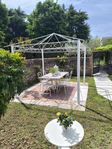 a white pergola with a table and chairs in a yard at Talamo Rooms in San Martino Buon Albergo