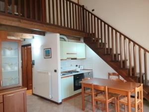 a kitchen with a wooden table and a staircase at Mulinaccio Appartamenti in Pievepelago +35 photos