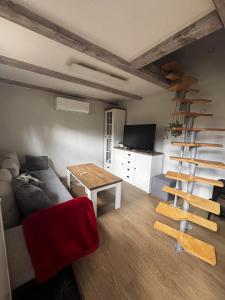 a living room with a couch and a spiral staircase at Domek se zahrádkou in Zbečno