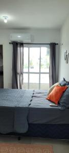 ein Schlafzimmer mit einem Bett und einem großen Fenster in der Unterkunft Frida's Corner in Caucaia
