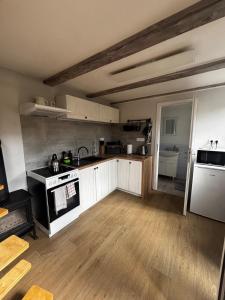 a kitchen with white cabinets and a stove top oven at Domek se zahrádkou in Zbečno