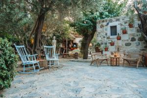 a group of chairs and tables in a yard with trees at Boleka Bodrum in Bodrum City