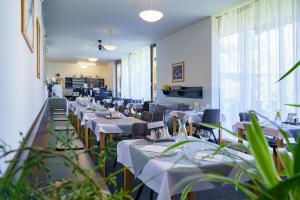 a dining room with white tables and chairs at Spa Sanatorium Dr Peták in Františkovy Lázně