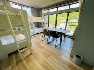 a room with a table and bunk beds at Cafe&Stay Stella in Minakami