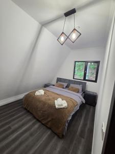 a bedroom with a large bed with two towels on it at The Robian Chalet in Suceviţa