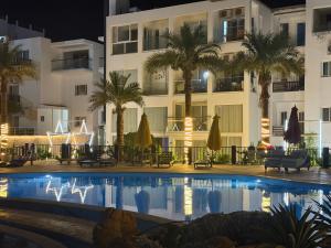 a hotel with a swimming pool in front of a building at Jasmine Studio Sharm El Sheikh in Dawwār Ruḩayyim