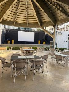 an outdoor patio with tables and chairs and a screen at Jasmine Studio Sharm El Sheikh in Dawwār Ruḩayyim