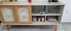 ein Schrank mit Tellern, Tassen und Schüsseln darin in der Unterkunft Frida's Corner in Caucaia + 13 Fotos