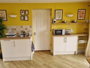 a kitchen with white cabinets and a sink at A quiet gem just outside Oundle in Oundle