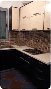 a kitchen with white cabinets and a stove at Adriatic Pearl Apartaments in Lezhë