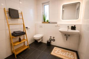 a bathroom with a sink and a toilet and a mirror at Schängel Chic 26 in Koblenz