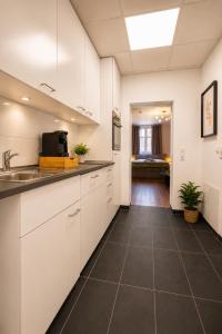 a kitchen with white cabinets and a tile floor at Schängel Chic 26 in Koblenz