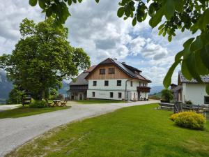 a large white house with a wooden roof at Appartement Schwarzkoglerhof in Haus im Ennstal