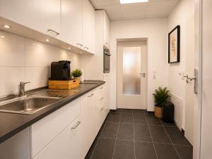a kitchen with white cabinets and a sink at Schängel Chic 26 in Koblenz