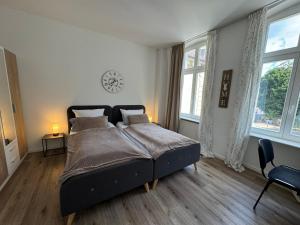 a bedroom with a bed and a clock on the wall at WOHNEN AM SCHLOSSPARK - Bad Salzuflen - nahe Messe, schnelles WLAN, freie Parkplätze, Frühstück verfügbar in Bad Salzuflen